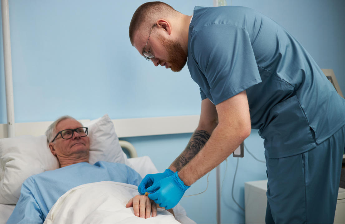 Certified nursing assistant providing bedside care to a patient in a healthcare facility